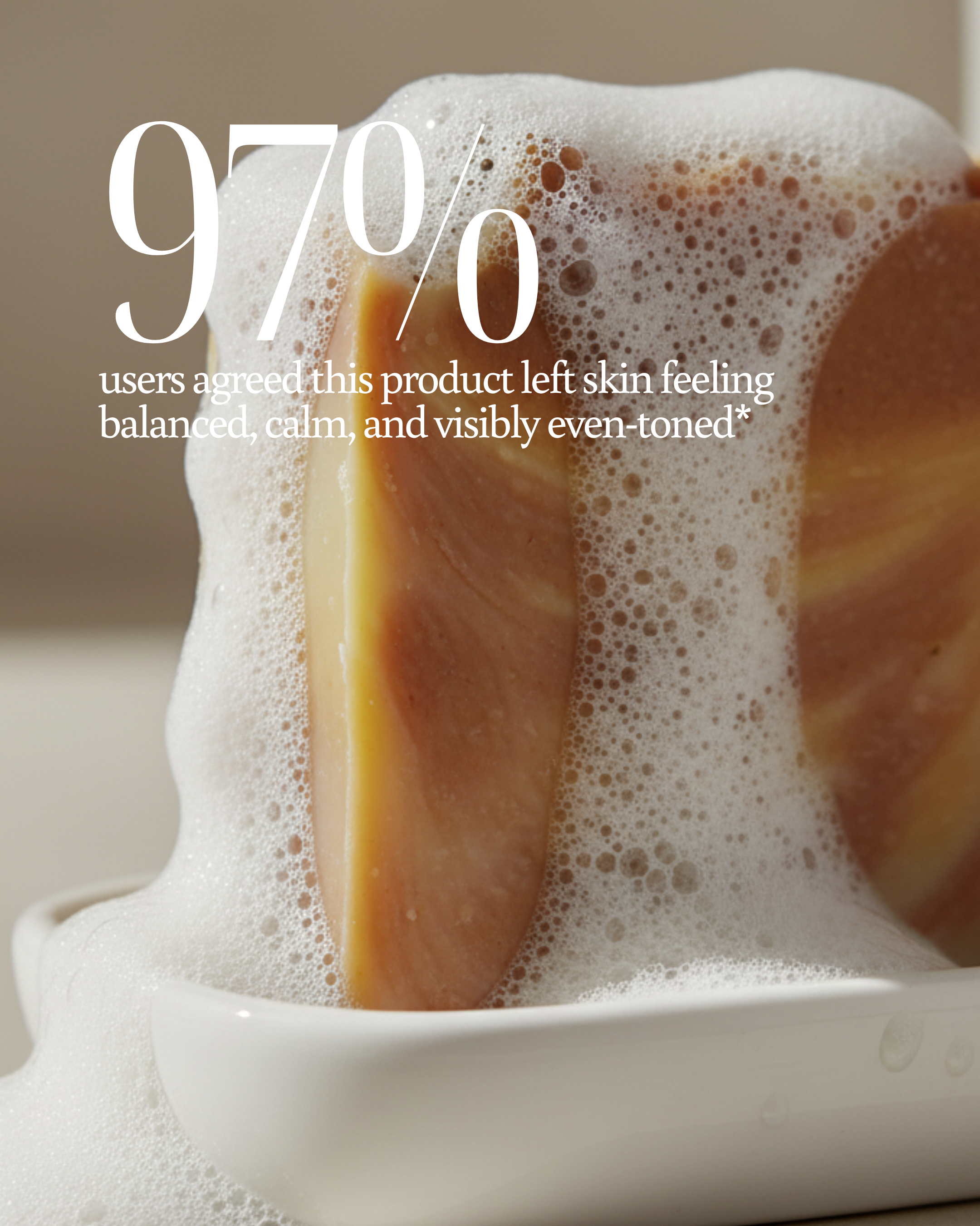 Close-up of a soap bar with foam and text about product user satisfaction reading "97% users agreed this product left skin feeling balanced, calm, and visibly even-toned*"