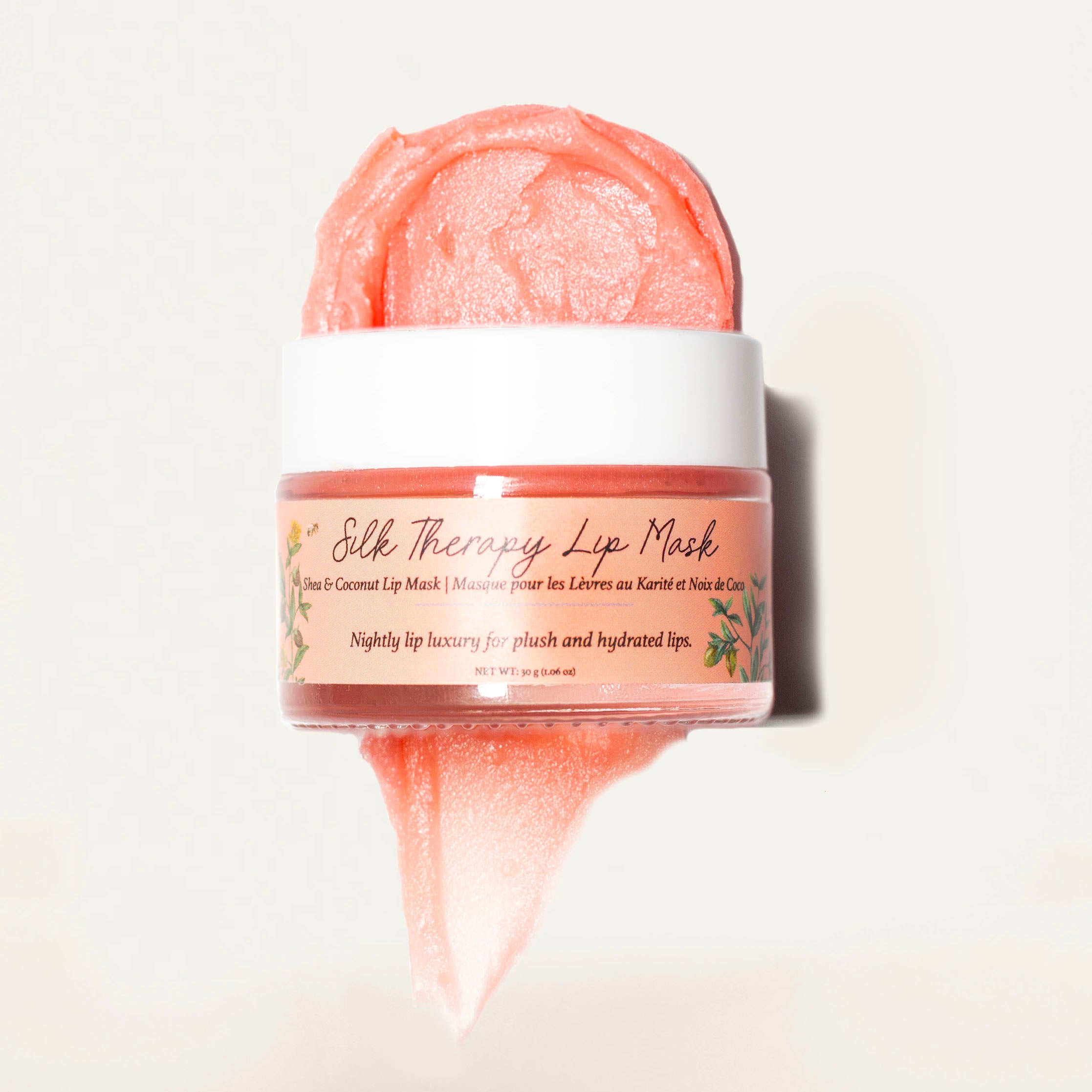 Hydrating lip mask made with nourishing ingredients like petroleum jelly, beeswax, jojoba oil, refined shea butter, carnauba wax, pink mica, vitamin E, and peppermint essential oil for smooth and moisturized lips.