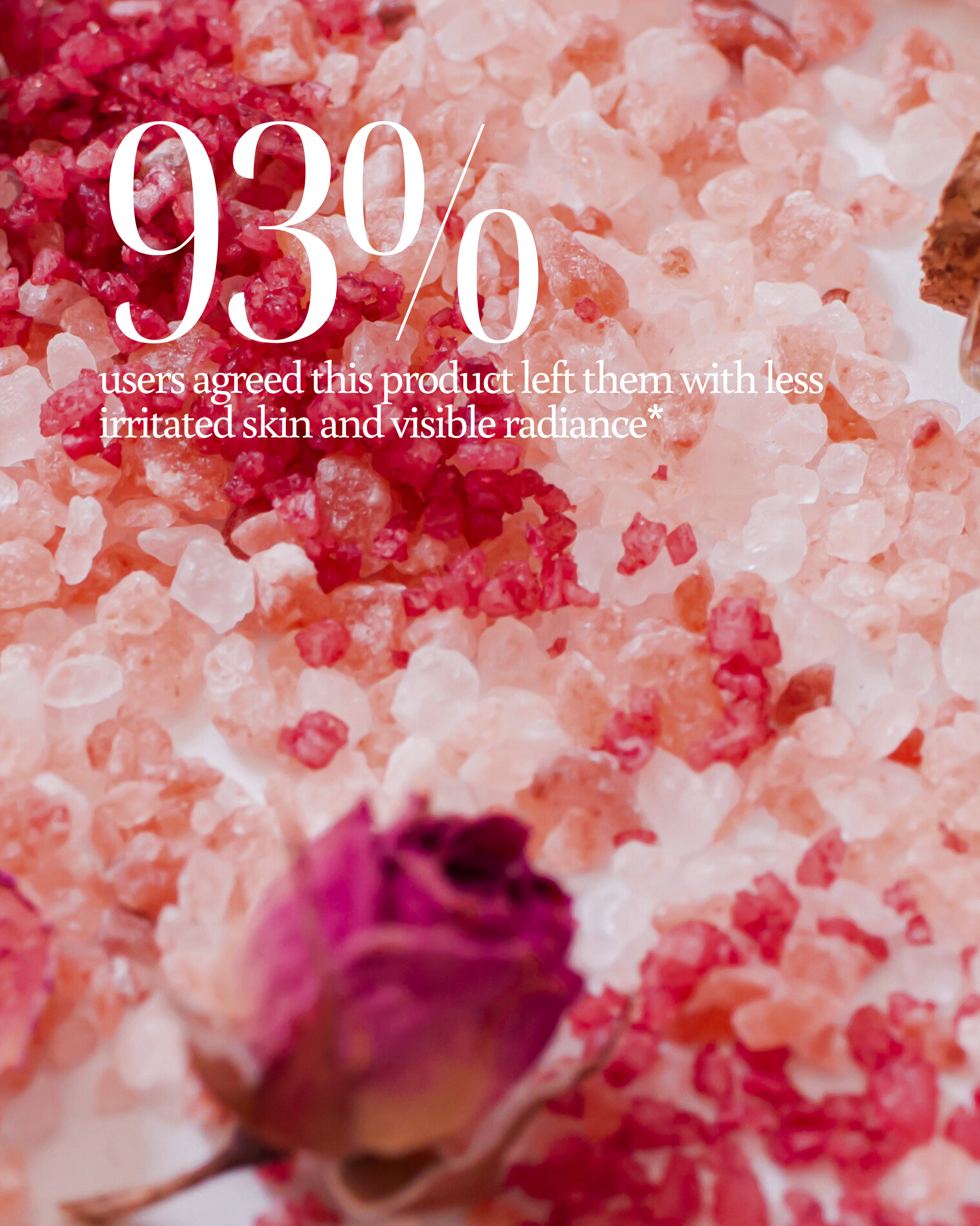 Close-up of pink bath salts with a rose, overlaid with text about product effectiveness reading "93% users agreed this product left them with less irritated skin and visible radiance*"