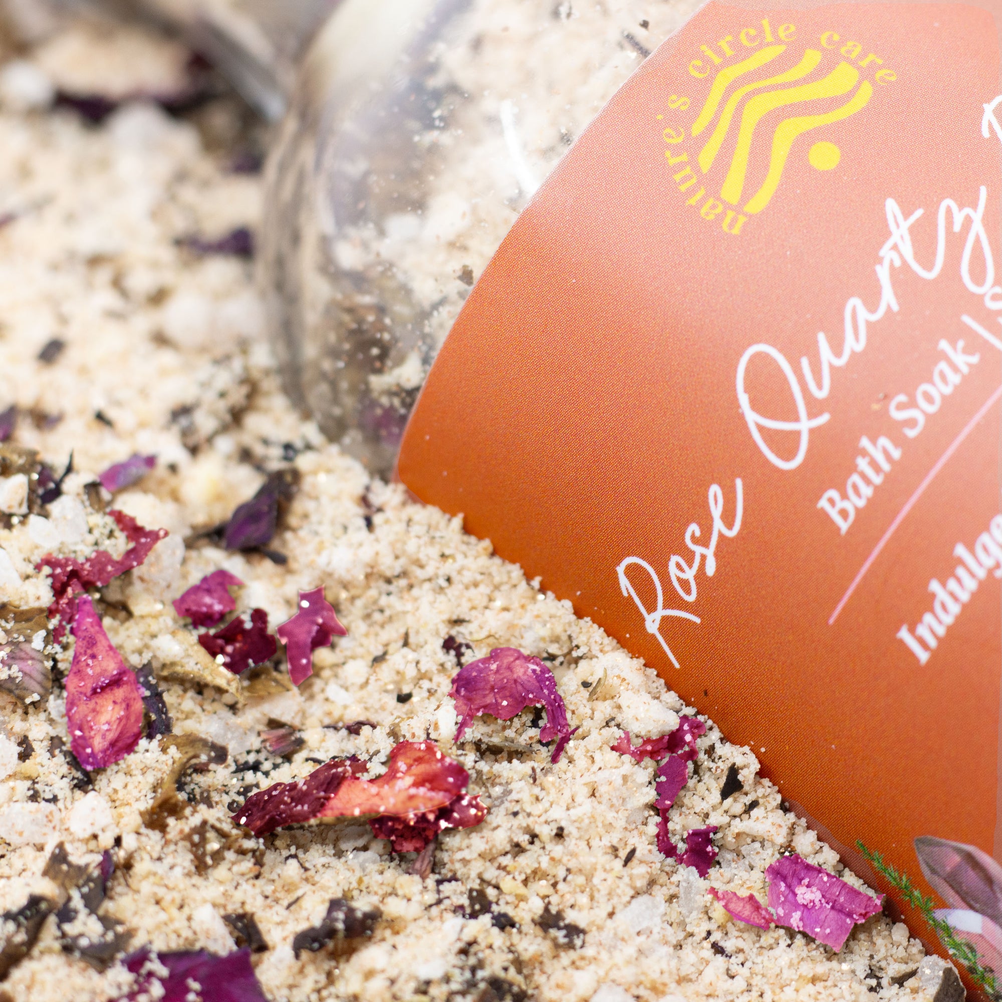 Rose-scented bath salt featuring Dead Sea salt, rose gold mica, rosehip seed oil, and red rose petals for soothing and revitalizing skin care.